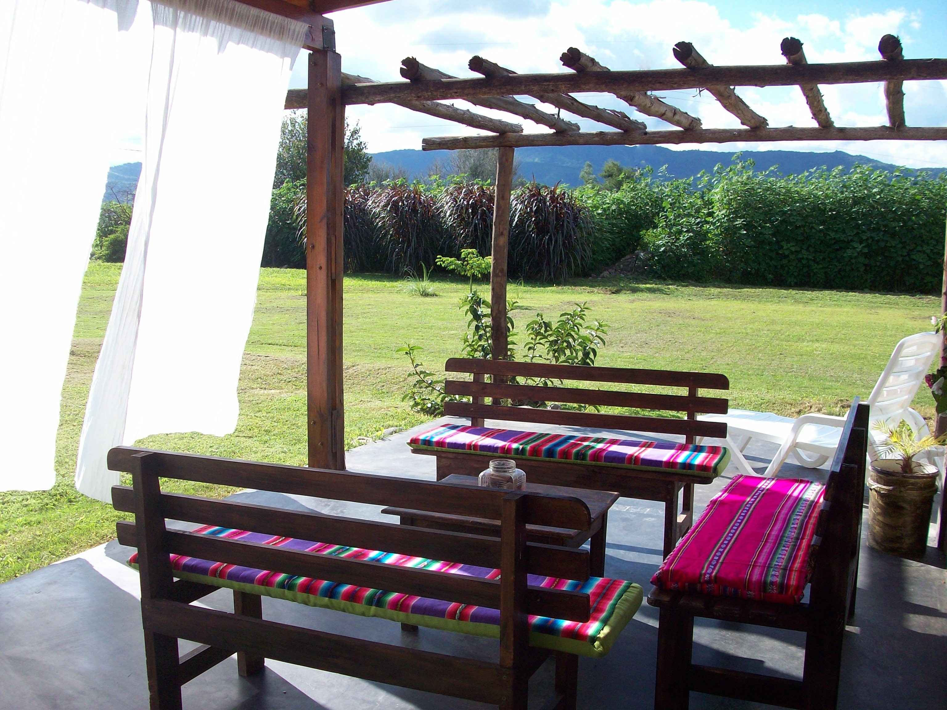 Pérgola con bancos de madera y tejidos típicos salteños - Alojamiento rural
