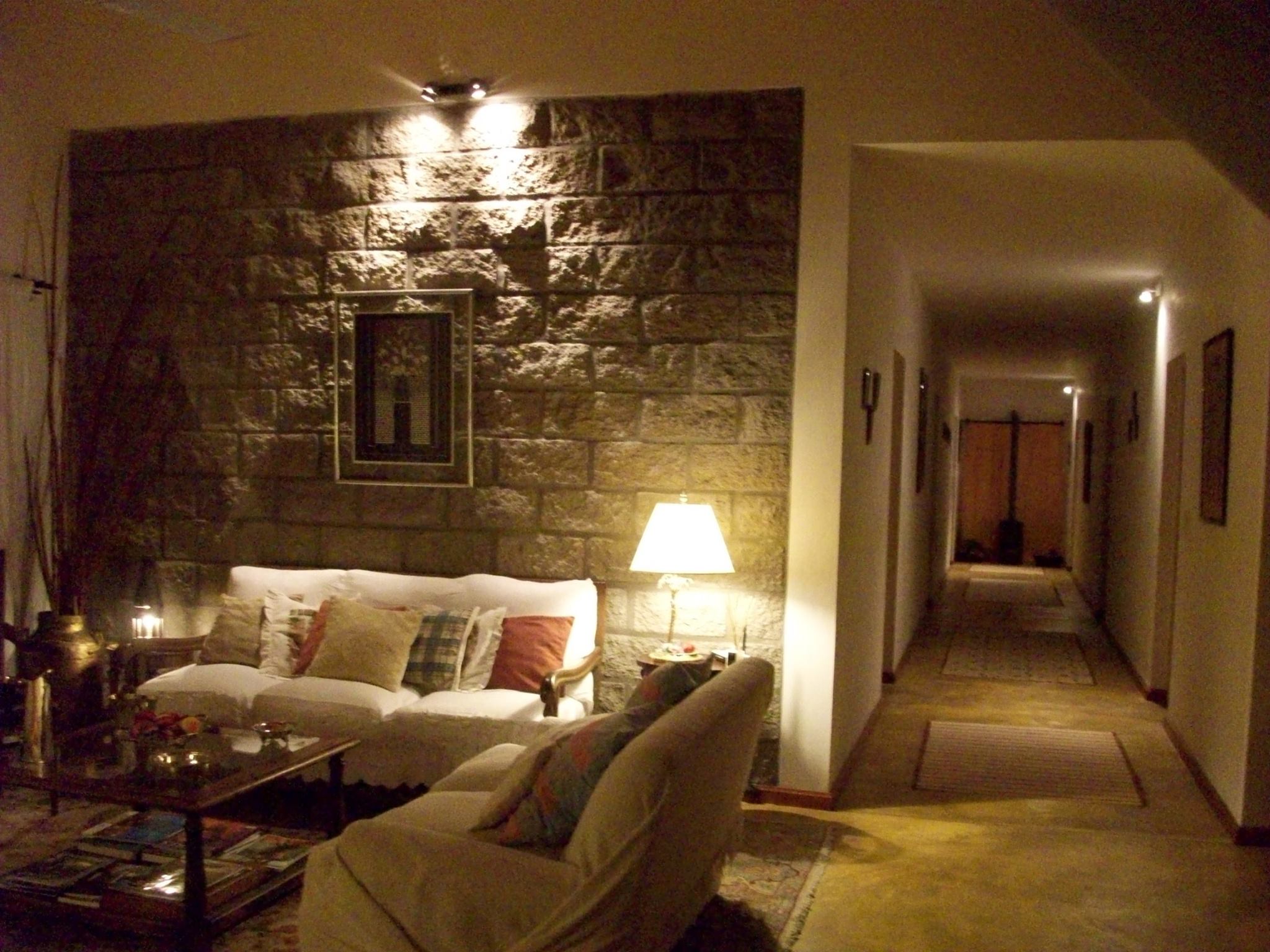 Living acogedor con sillones y pared de piedra - Finca La Vertiente Salta