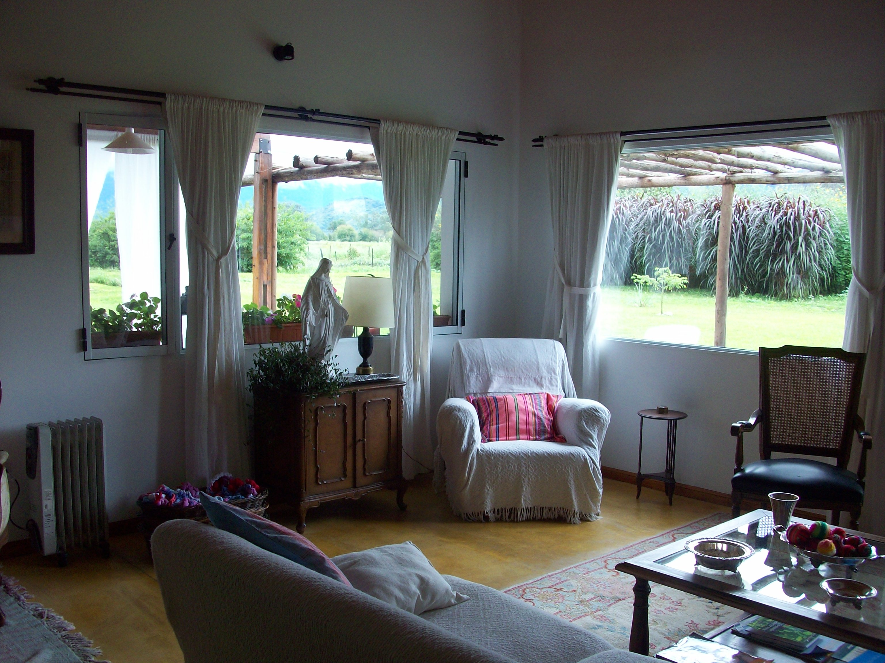 Living luminoso con sillones y vista al jardín - Hotel boutique Salta