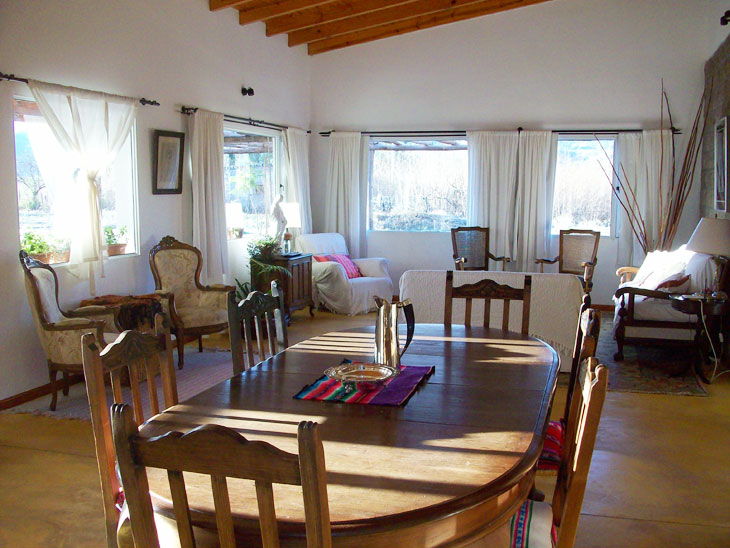 Living comedor con muebles de estilo y luz natural - Hotel de campo en Salta